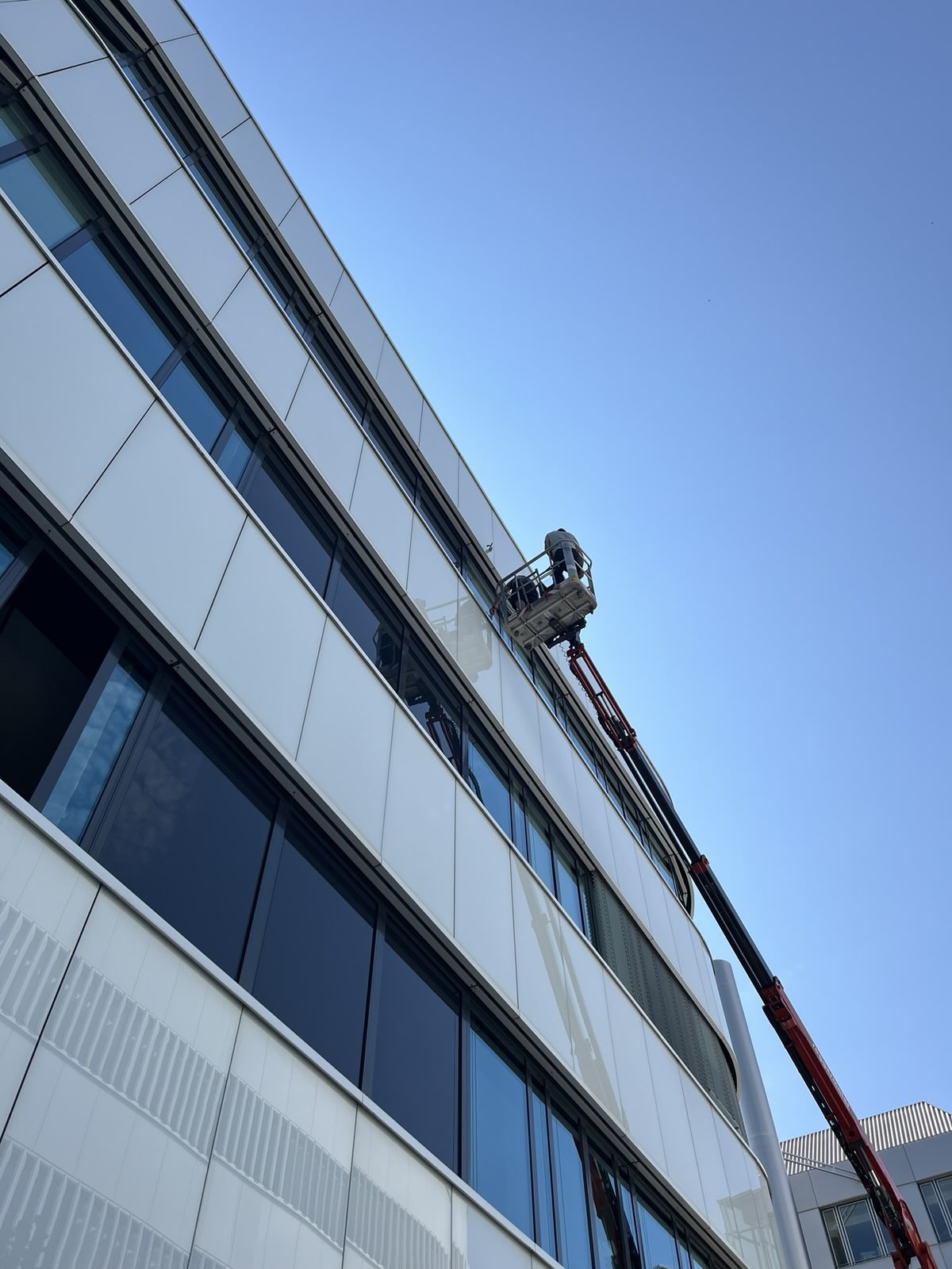 Folienmontage an einer Bürofassade mit Hubsteiger